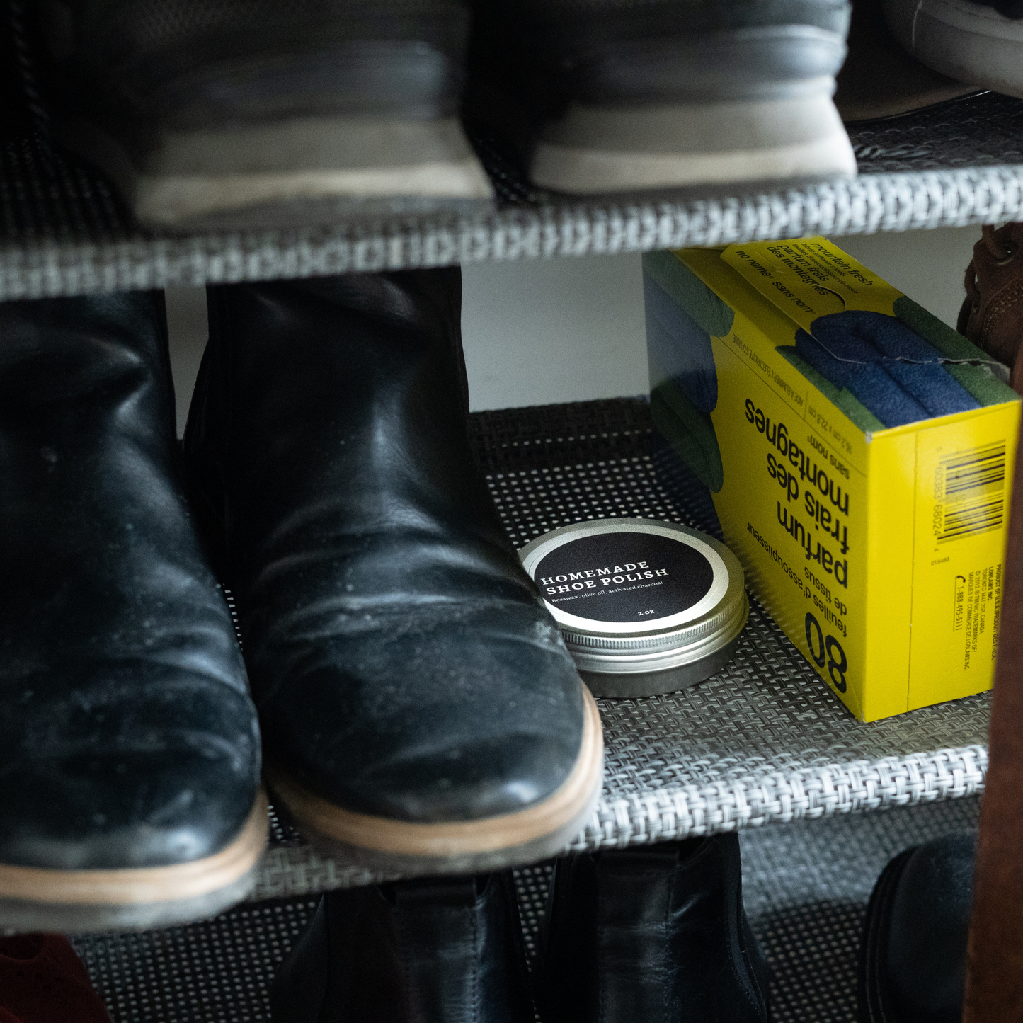 Homemade Shoe Polish tin discreetly placed on a shoe rack next to boots and cleaning supplies, ideal for storing crypto wallets or seed phrases securely.