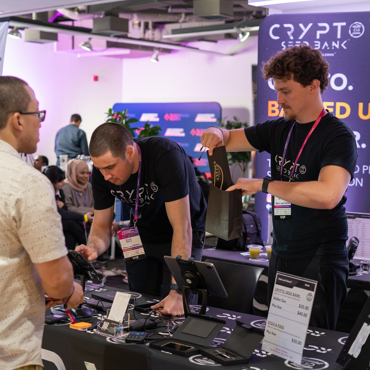 Emmet Robins and Edward Coleman helping a visitor at the Crypto Seed Bank™ booth.